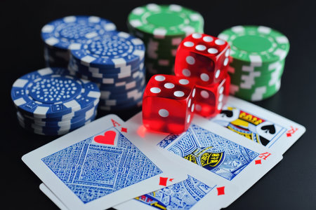 A close-up view of playing cards, dice, and poker chips arranged on a dark table at a social gathering.の写真素材