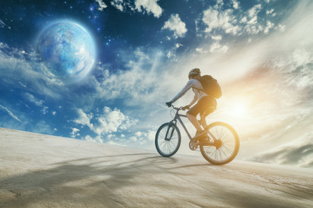 Cyclist navigates a sandy terrain beneath an expansive sky filled with clouds.の写真素材
