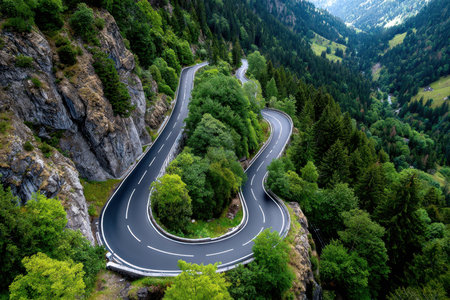 An aerial view of a winding road through a green valleyの写真素材