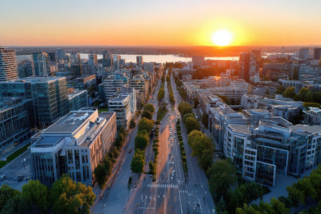 Aerial view of a city street at sunset with modern buildings and trafficの写真素材