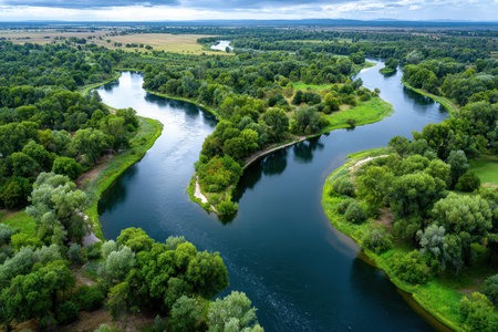 An aerial view of a winding river flowing through a lush green landscapeの写真素材