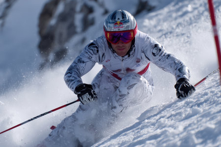 A competitive skier navigates a challenging course, carving through powder on a bright winter day.の素材