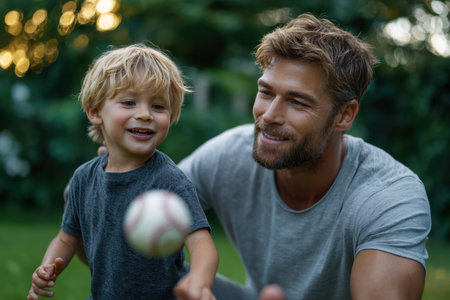 A father and his young son play catch with a baseball in a vibrant garden at dusk, enjoying their time together.の素材