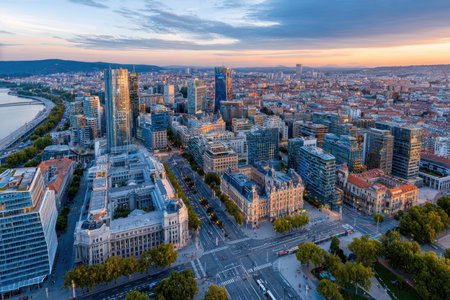 An aerial view of a city at sunset with colorful sky and many buildingsの写真素材