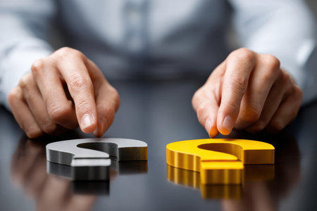 Two hands hover over yellow and gray question marks on a table, indicating a choice in decision making.の写真素材