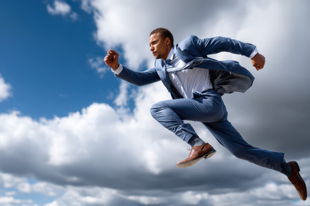 A man in a suit sprints confidently against a backdrop of cloudy skies, symbolizing ambition and drive.の写真素材