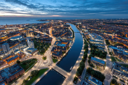 An aerial view of a city at twilight with a river flowing through itの写真素材