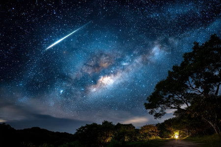 Bright stars and the Milky Way illuminate the night sky, while a shooting star streaks above a peaceful natural setting.の写真素材