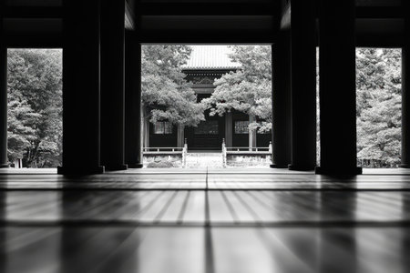 Tranquil view from inside a temple, framed by wooden pillars and lush greenery outside.の素材