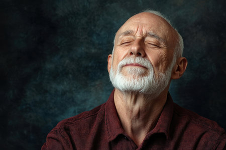 An elderly man with a beard experiences tranquility, eyes closed, suggesting a peaceful moment of reflection.の素材