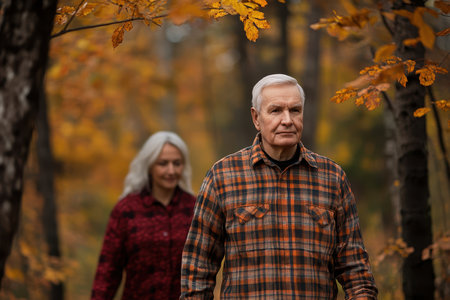 A man and woman stroll together amid vibrant autumn foliage, enjoying the serene nature around them.の素材
