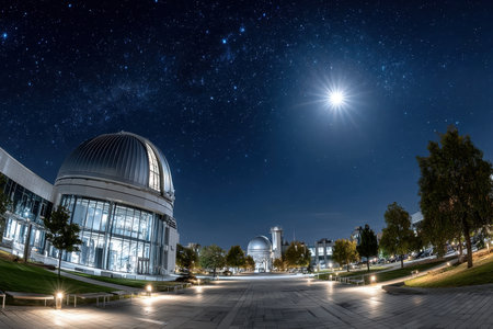 An observatory with domed roofs stands beneath a starry night sky illuminated by the moonの写真素材