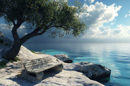 A wooden bench sits beside the tranquil sea under a tree, against a backdrop of clouds and clear water.の素材