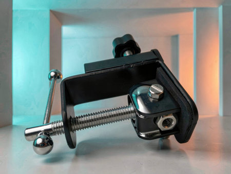 A heavy duty metal clamp sits on a white surface