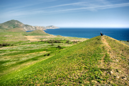 Spring landscape with hills, sea and manの写真素材