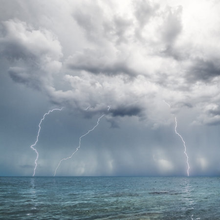 Lightning and thunderstorm above sea in the day