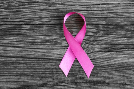 health symbol pink ribbon on wooden board background.の写真素材