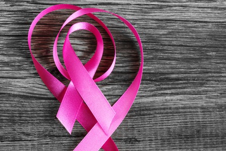 health symbol pink ribbon on wooden board background.の写真素材