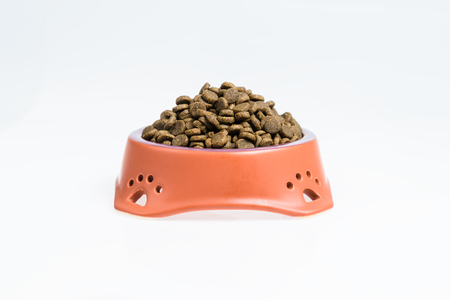Ceramic bowl with dried pet food on white backgroundの写真素材