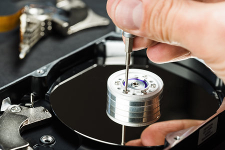 Repairman disassembling hard disc drive hdd close-up.