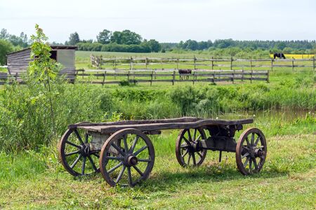 old wooden cart wagon green grass landscapeの写真素材