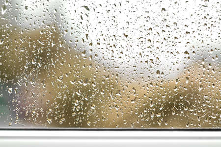 Rain drops on window glasses surface blurred autumn viewの写真素材
