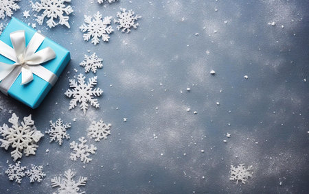 Christmas background toned background with blue wrapped gift and snowflakes. Top view, overhead, copy space on the left side of the bannerの素材