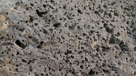 Close-up of the surface of an old stone with holes.の写真素材