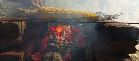 Cooking corn on the coals over a fire in a restaurant