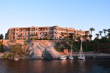 River Nile/ beautiful view for Aswan Egypt and Nubian Egyptian culture. sailing boat sailing in the River Nile and harbor with birds and local houses on the 2 sidesのeditorial素材
