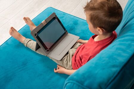 Preschooler watches tablet at home. Leisure at homeの写真素材