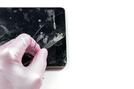 Dirty broken tablet screen. Hand removing protective filmの写真素材