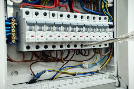 Electrician testing the electrical shield. Electrical switchboard with automatsの写真素材