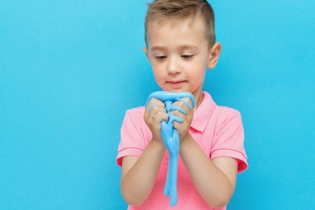 Funny boy playing with blue homemade slimeの写真素材