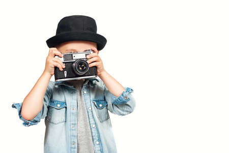 Photographer kid taking a photo with vintage retro cameraの写真素材