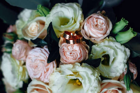 Wedding rings on a rose bud. Gold wedding ringsの写真素材