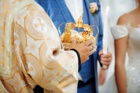 Close up of cristian priest hands with crown for weddingの写真素材