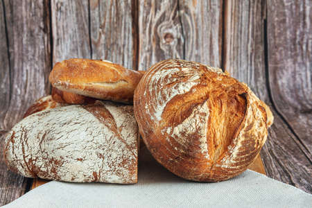 Assortment of baked bread on wooden table backgroundの写真素材