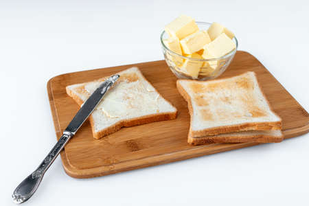 Tasty toasted bread with butter on wooden boardの写真素材