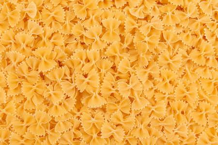 Raw farfalle pasta background. Close up of uncooked farfalle pasta. Top viewの写真素材