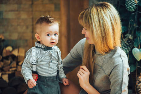 Christmas, family, mother and son in the studio with New Years decor, everyone is happy. Winter holiday concept. Merry Christmas and Happy Holidaysの写真素材