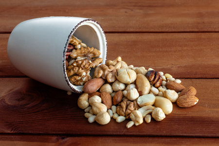 Scattered mixed nuts on dark wooden background. Healthy food and snackの写真素材
