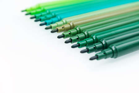 Set of green colored marker pen on isolated background. Different shades of green. Selective focus. Poster with copy spaceの写真素材