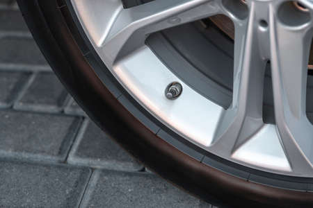 Closeup of car wheel nipple. A fragment of the wheel of the car with the nipple. A part of an aluminum disk of car.の写真素材