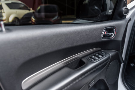 Mirror control knob and window control panel in a modern car. Automatic car window controls and...