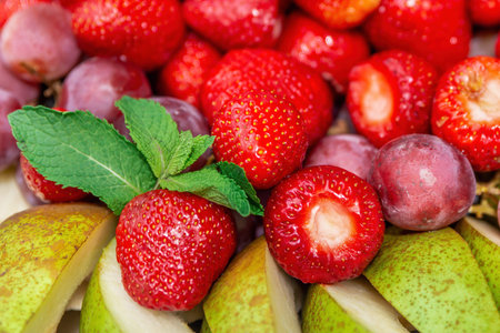 Close up of fresh fruit and berries. Strawberries, slicing pear and grapes. Summer fruit background...