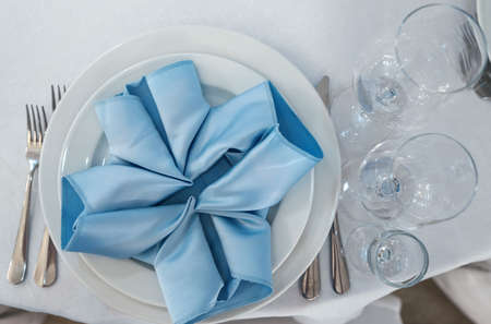 Beautiful table setting on white linen tablecloth. Festive luxury table setting for wedding dinner. Top view.の写真素材
