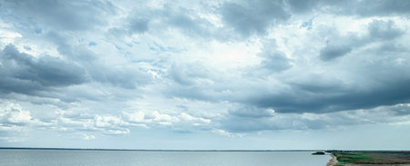 Blue calm sea and sky with clouds. Dramatic pre-storm sky with clouds and gaps.