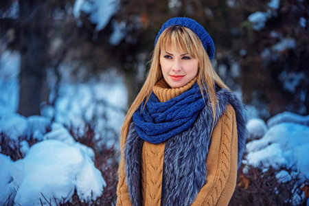 Christmas, New Year holidays, winter concept: happy smiling woman posing in winter park. Model...