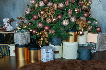 Christmas presents near tree with colorful balls. Stacked gift boxes for christmas.